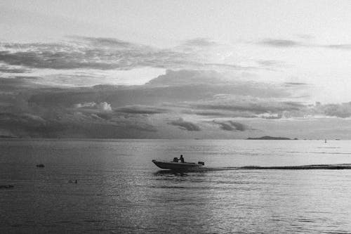 
A Grayscale of a Person Operating a Speedboat