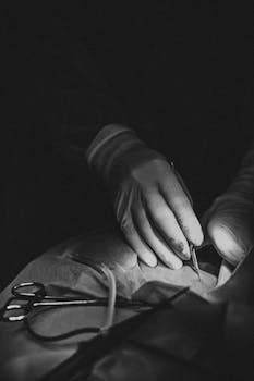 Detailed black and white shot of a surgeon performing a surgical procedure in an operating room.