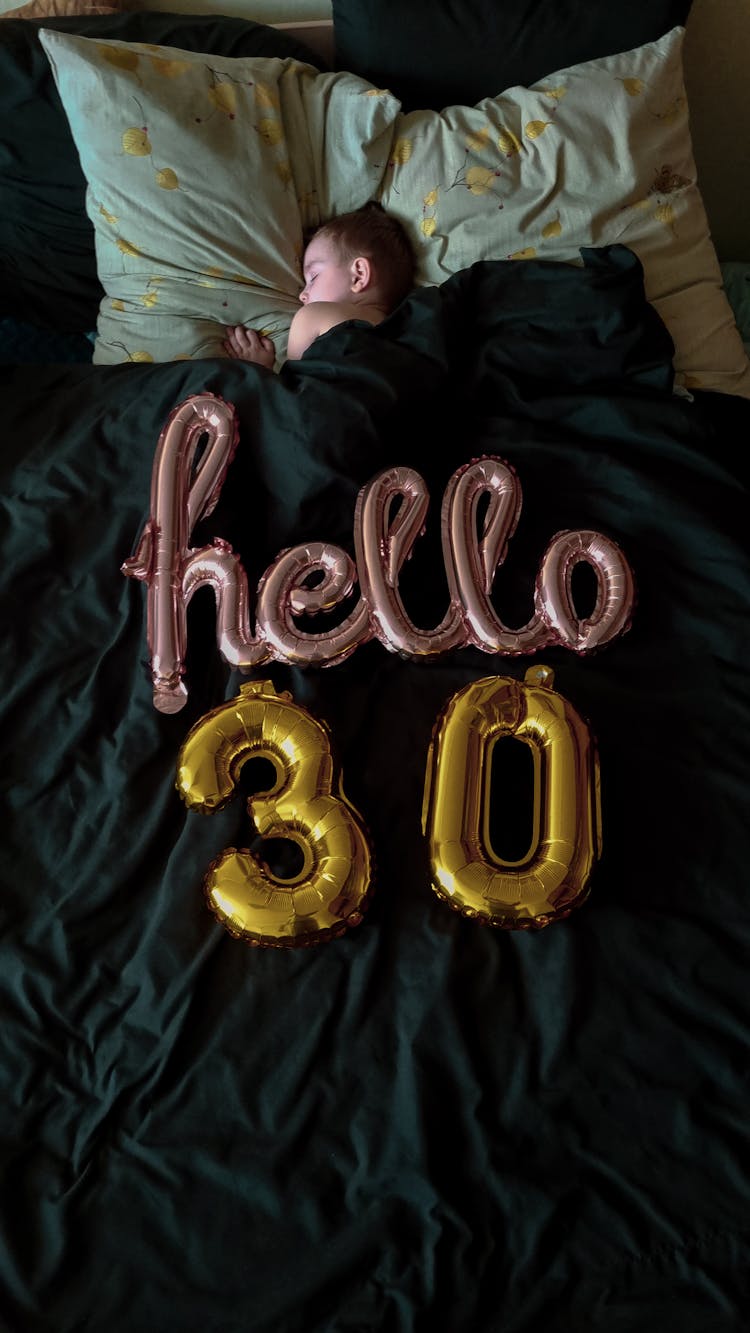 Balloons For Birthday Party On Woman In Bed