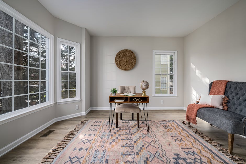 A stylishly decorated garage conversion, featuring a comfortable seating area, a desk, and large windows bringing in natural light, showcasing its versatility as a home office or guest suite. - Garage conversion plans A stylishly decorated garage conversion, featuring a comfortable seating area, a desk, and large windows bringing in natural light, showcasing its versatility as a home office or guest suite. - Garage conversion plans