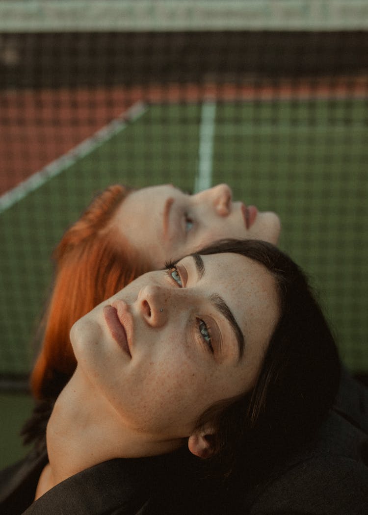 Women Leaning On Each Other Looking Up