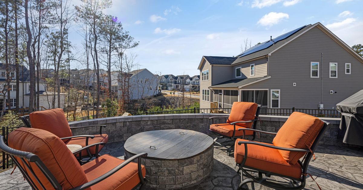 Cozy outdoor patio with chairs and firepit overlooking a beautiful residential neighborhood.