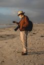 Man in Brown Jacket taking Photo of the Sea