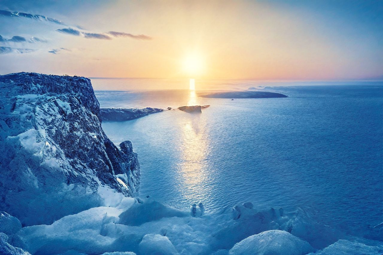 a breathtaking sunrise above a frozen coastline illuminating the sea w