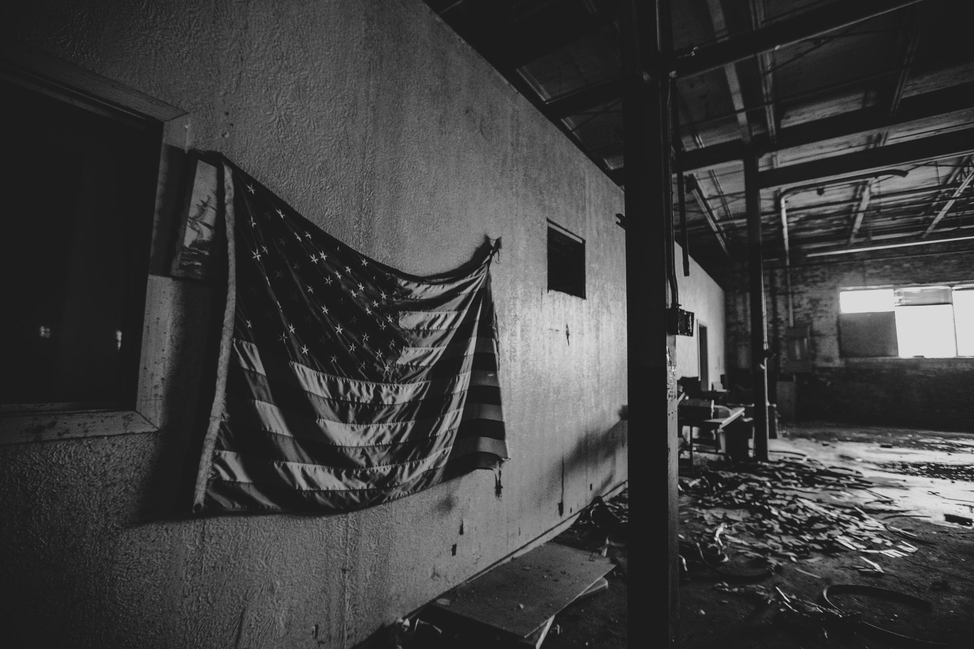 Nave industrial vacía con una bandera estadounidense en la pared.