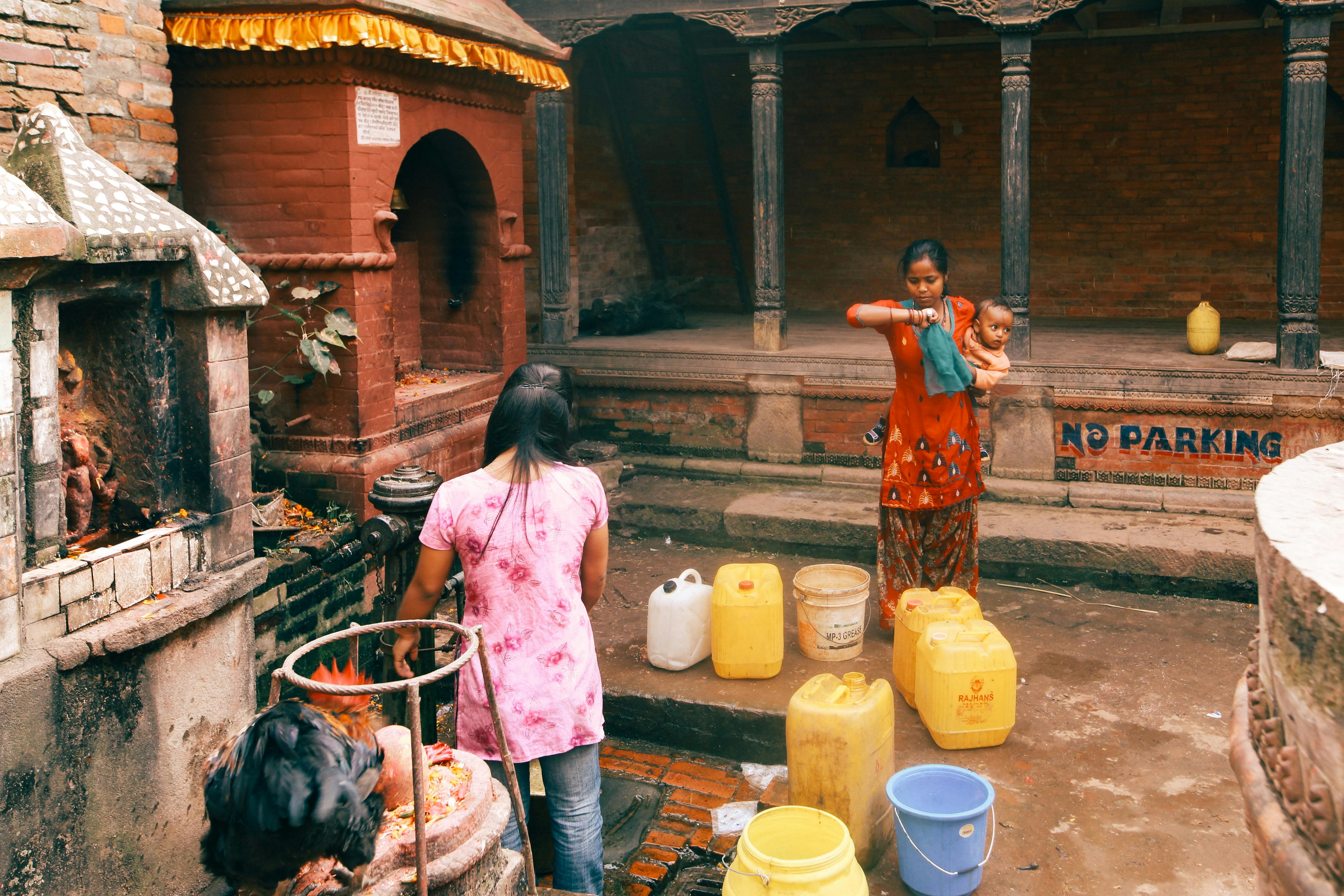 Kırsal alanda bidonlarla su taşıyan insanlar, water access sorununa örnek