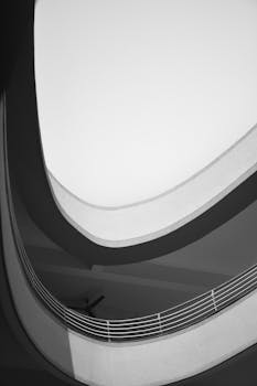 Black and white minimalist view of modern architectural curves and light.