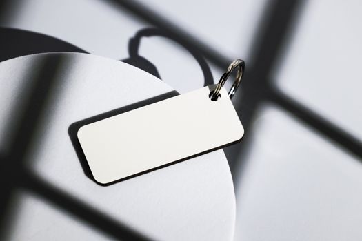 Elegant keychain on abstract shadows cast by natural light, close-up shot.