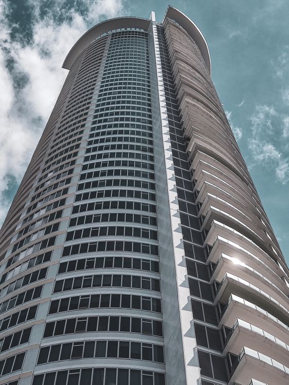 A Low Angle Shot of a Building Under the Cloudy Sky · Free Stock Photo