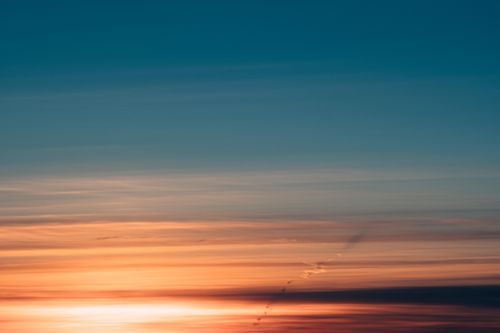 Free Capture of a serene sunset featuring vibrant colors and dramatic cloudscape. Ideal for nature and sky enthusiasts. Stock Photo