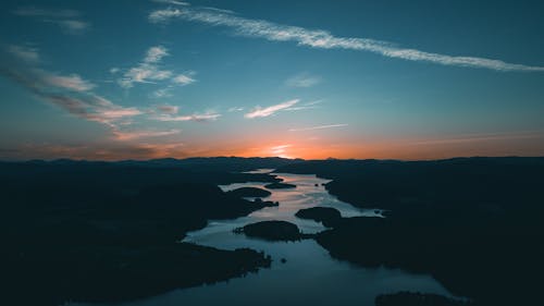 Free Aerial Photography of Water Beside Forest during Golden Hour Stock Photo