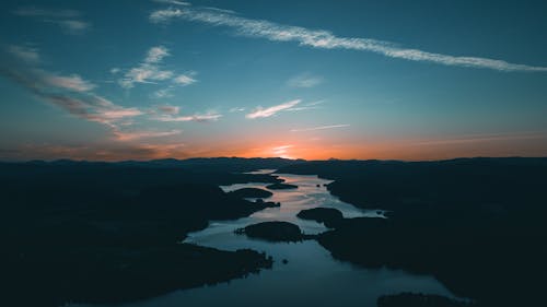 Aerial Photography of Water Beside Forest during Golden Hour