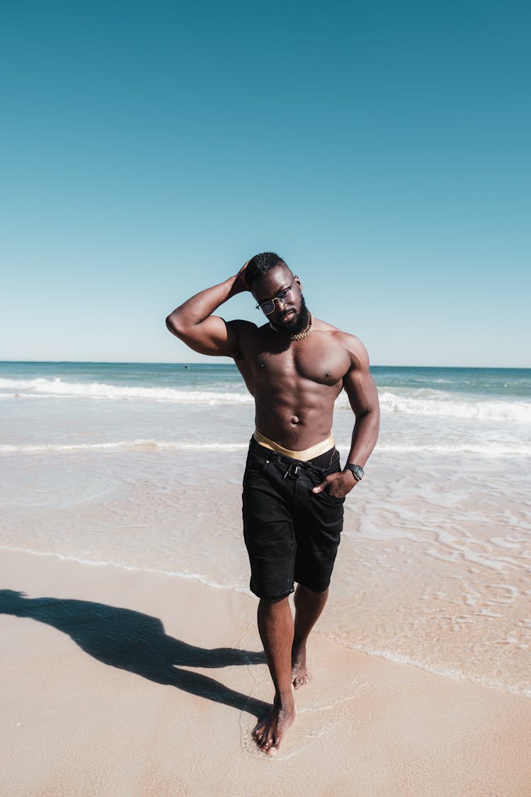 Man In Black Shorts Standing On Beach