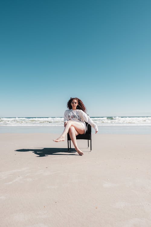 Free Woman Sitting on Chair on Beach Stock Photo