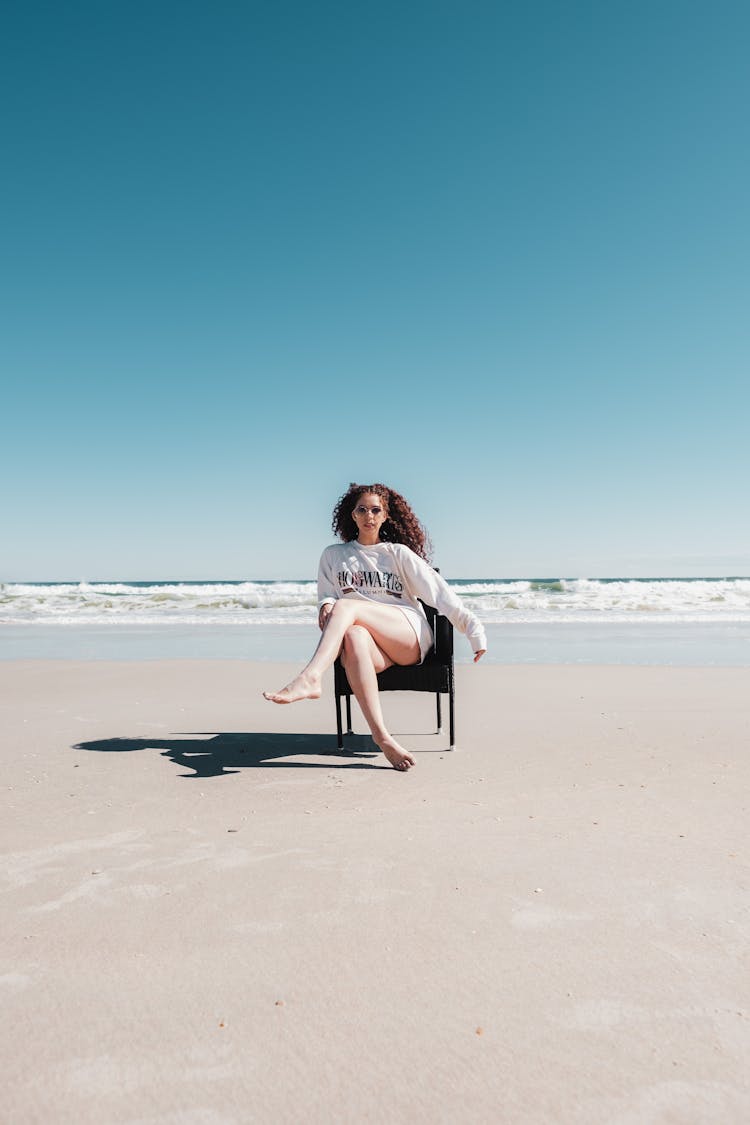 Woman Sitting On Chair On Beach