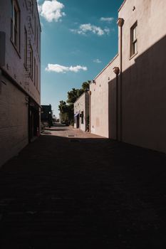 A scenic alleyway in Lakeland, FL, showcasing architecture under a bright blue sky.