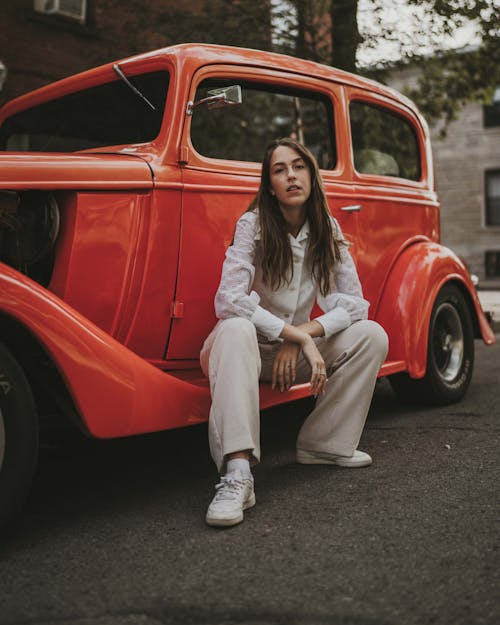 Young Woman Sitting on Retro Car