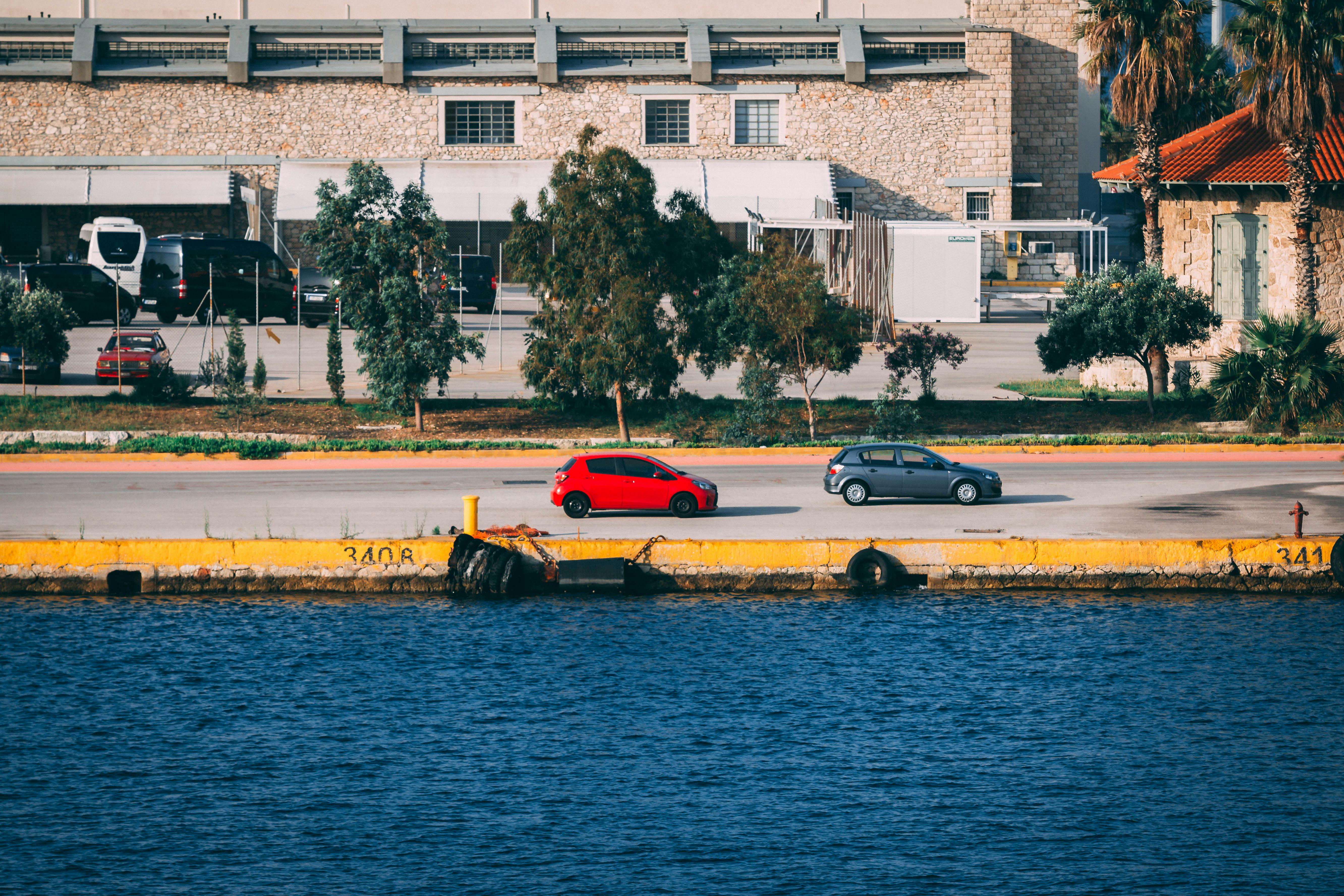 充满活力的海滨城市景观中，汽车停在工业风格的建筑旁