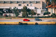 充满活力的海滨城市景观中，汽车停在工业风格的建筑旁