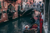 在充满活力的威尼斯，贡多拉穿过传统桥下的风景
