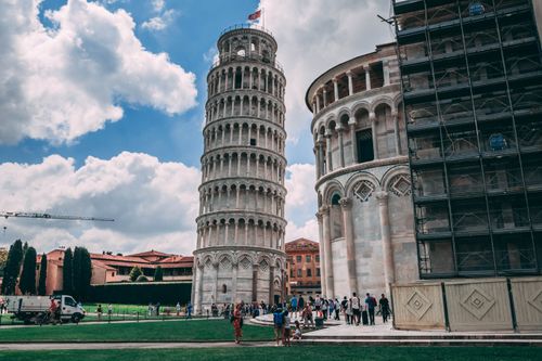Free Capture of the iconic Leaning Tower of Pisa and tourists enjoying a sunny day. Stock Photo
