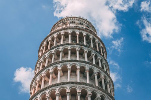 Free Low angle view of the iconic Leaning Tower of Pisa with a clear blue sky in the background. Stock Photo