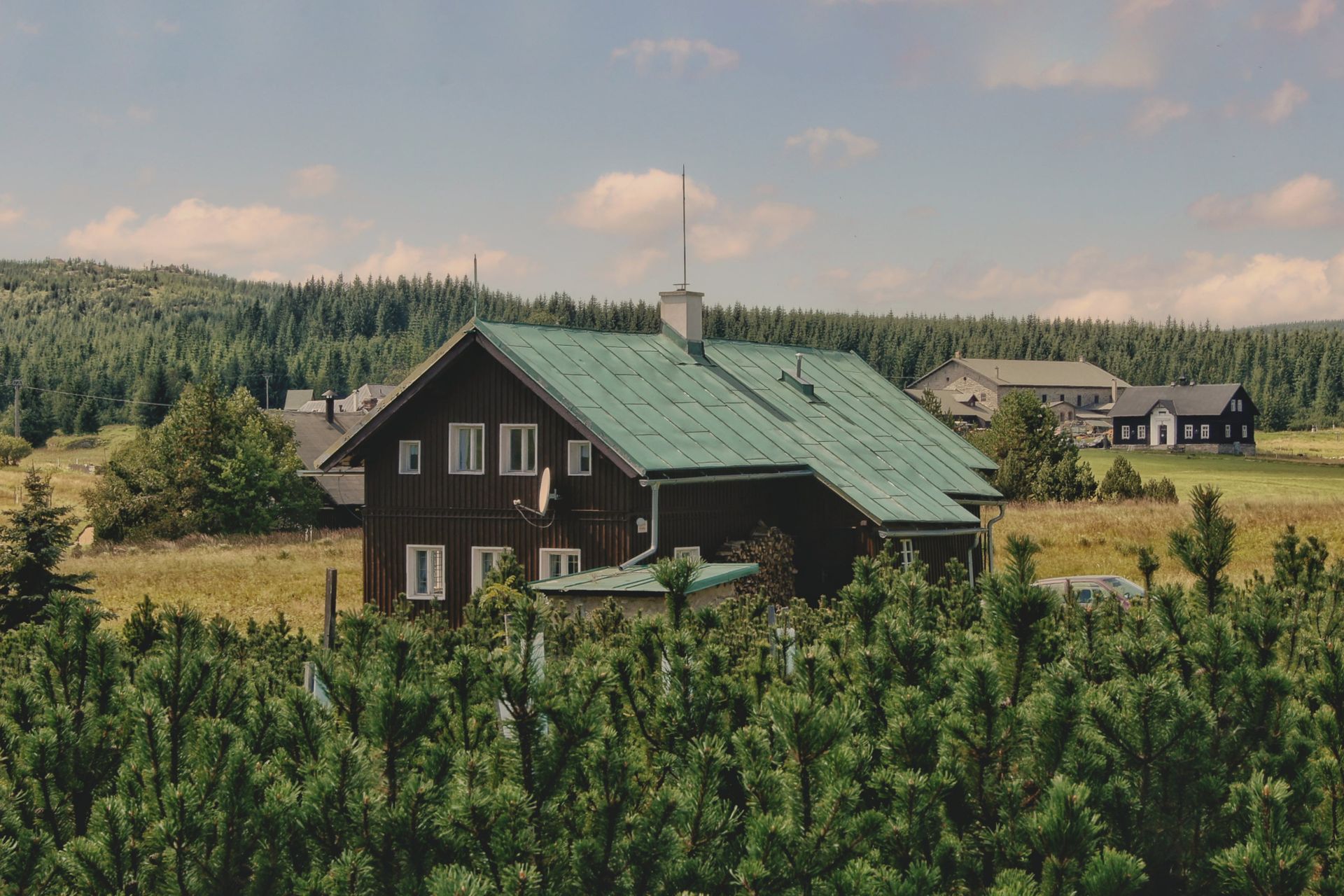 Rustic countryside home amidst lush greenery in Liberecký kraj, Czechia, during summer.