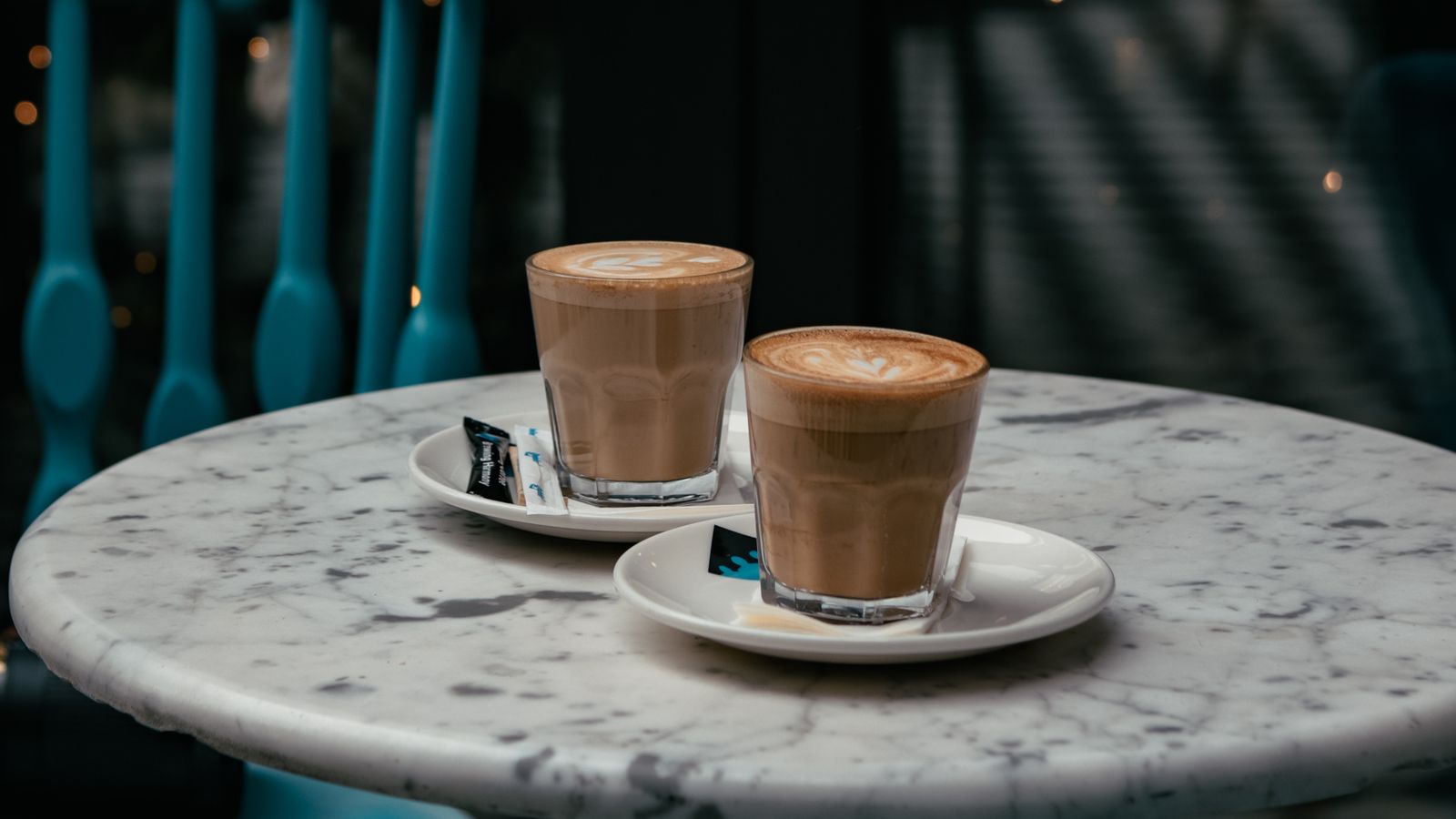 Two glasses of coffee on a marble café table