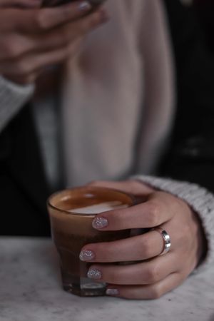 Hands holding a latte, photo by Esra Afsar on Pexels