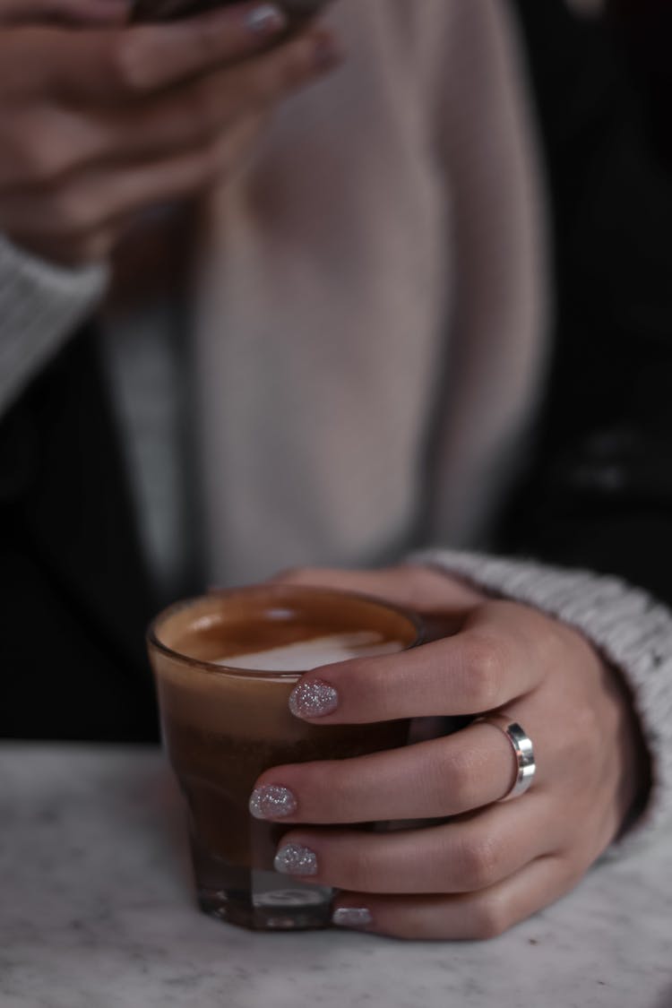 Close-up Of Woman Hand Holding Coffee In Glass