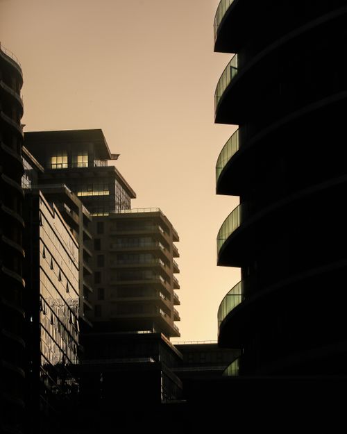 Free Modern city skyscrapers silhouetted against a twilight sky, creating dramatic urban vistas. Stock Photo