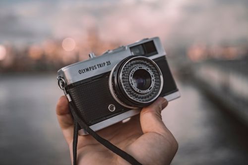 Free A classic Olympus Trip 35 camera held against the Bosphorus backdrop in Istanbul. Stock Photo