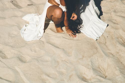 Woman in White Dress Sitting on the Sand