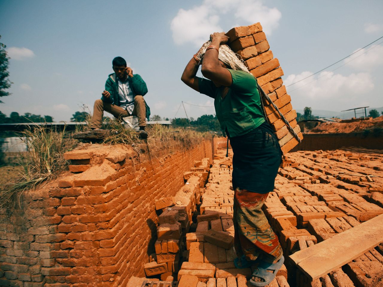 man and woman working in a brick kiln outdoor labor scene