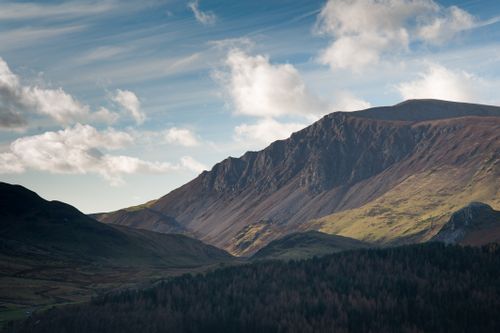 Free Majestic mountain range beneath a clear blue sky with white clouds. Stock Photo