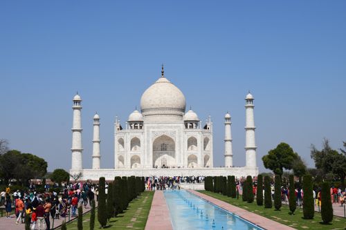 Free Iconic Taj Mahal in Agra with tourists under a clear blue sky. Stock Photo