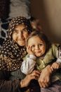 Elderly Woman in Kerchief on Head Holding Child on Her Lap