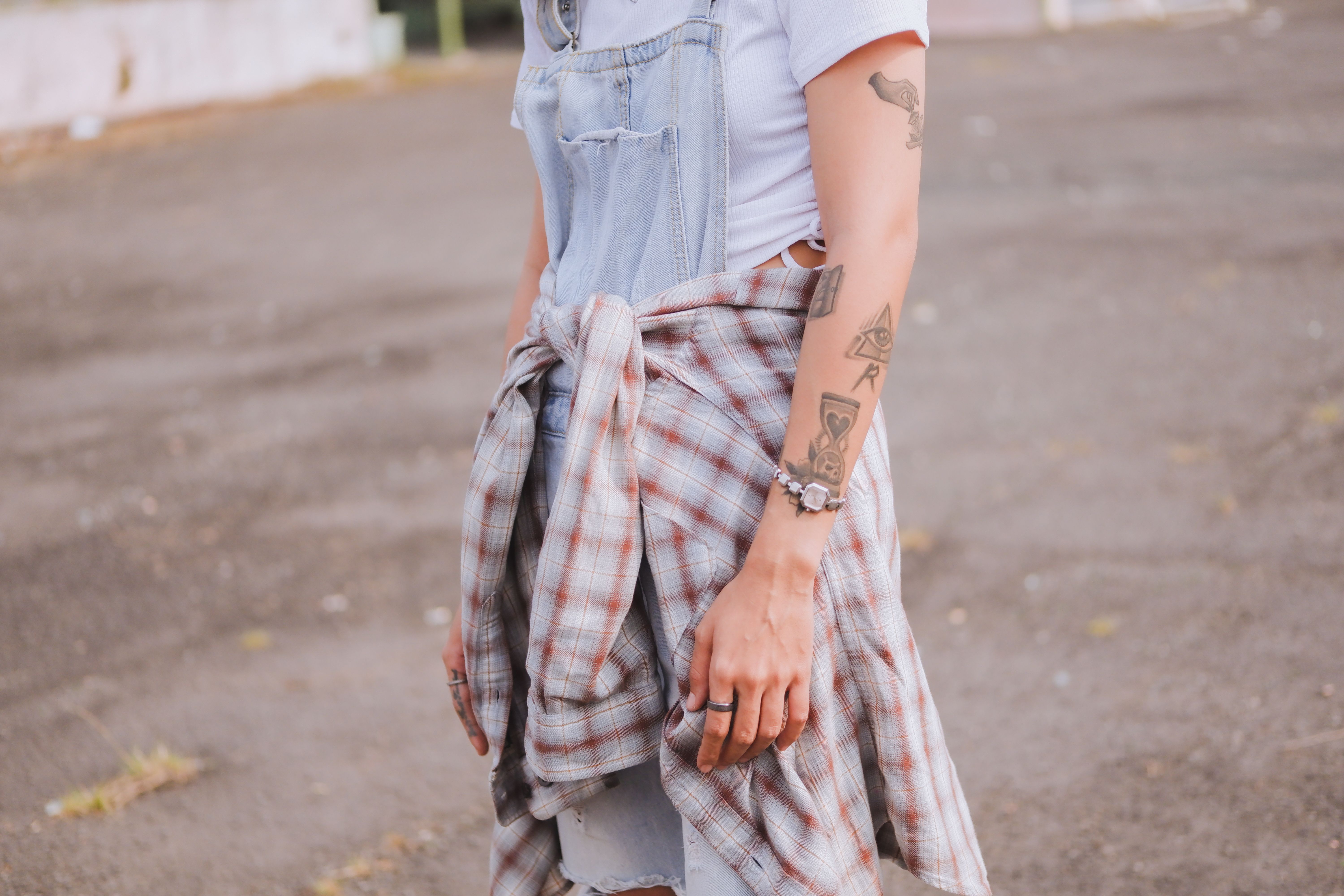 Jeune femme portant des tatouages temporaires discrets sur la cheville et le poignet dans un look casual