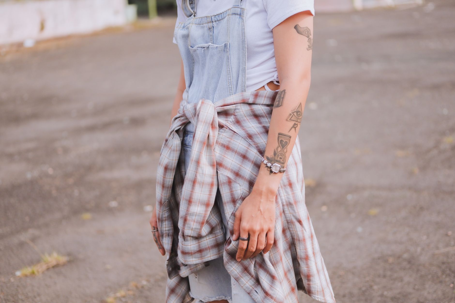 Jeune femme portant des tatouages temporaires discrets sur la cheville et le poignet dans un look casual