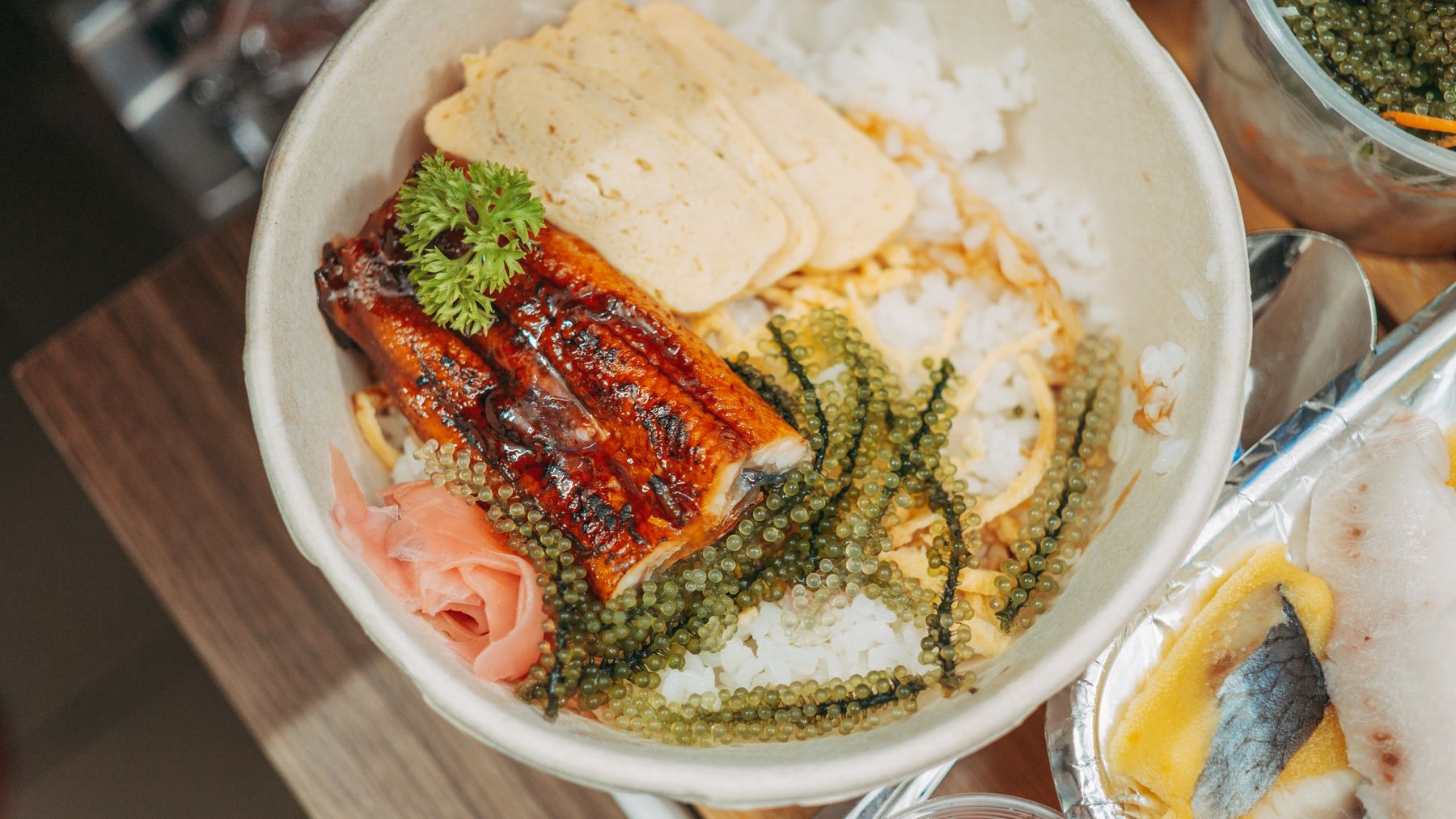Close-up of a Japanese unagi rice bowl with seaweed, parsley, and tamagoyaki, perfect for food photography.