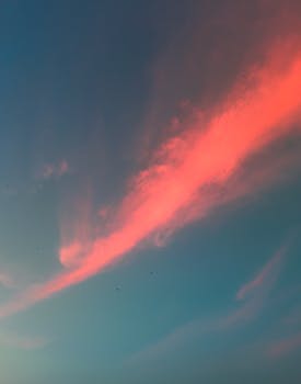 A stunning blend of pink and blue hues in the evening sky showcasing a dynamic cloud formation.