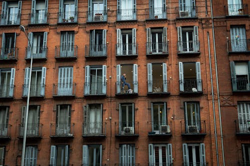 A Man Standing on the Balcony of an Apartment Building
