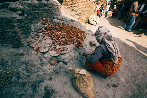 Free A woman crafting pottery in an urban market, showcasing traditional skills and cultural heritage. Stock Photo