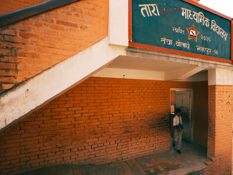 Student Holding A Book While Getting Out Of The Classroom