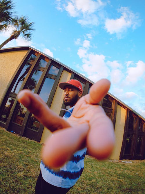 Man Wearing Red Cap Reaching Out