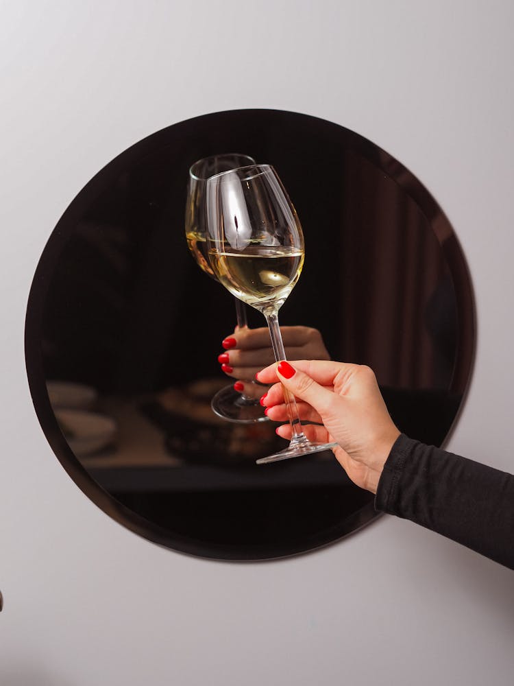 Unrecognizable Female Hand Holding Glass Of White Wine 