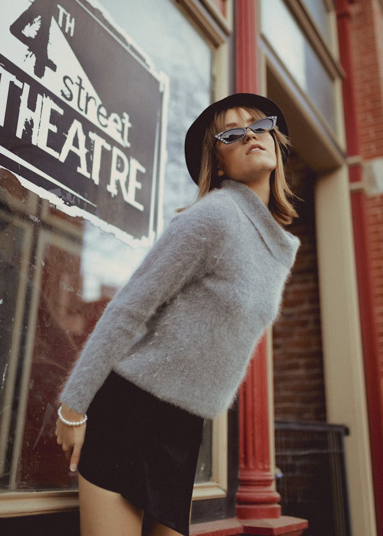 Woman In Sweater Posing In Front Of Theatre Entrance