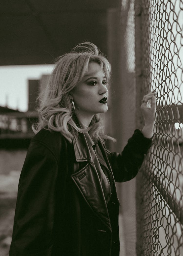 Black And White Portrait Of Woman Waiting By Airport Fence