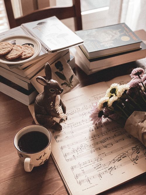 Free Rustic tabletop with coffee, sheet music, and flowers creates a cozy, vintage ambiance. Stock Photo