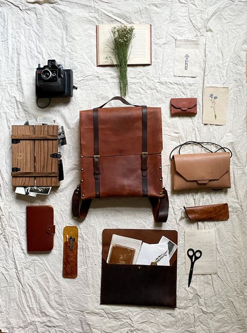 Free A styled flat lay featuring vintage leather bags, a retro camera, and travel accessories. Stock Photo